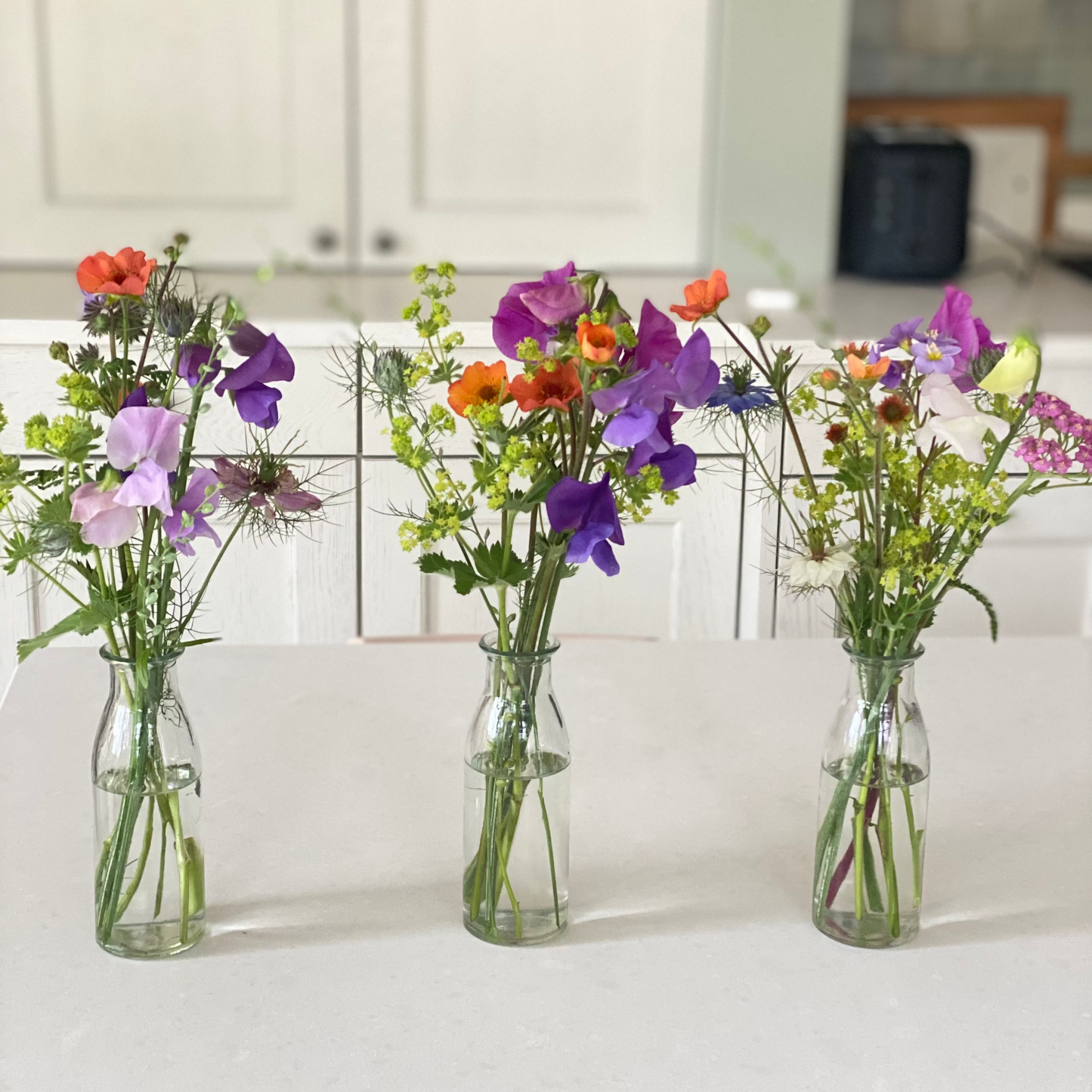 Filled table vases with seasonal flowers
