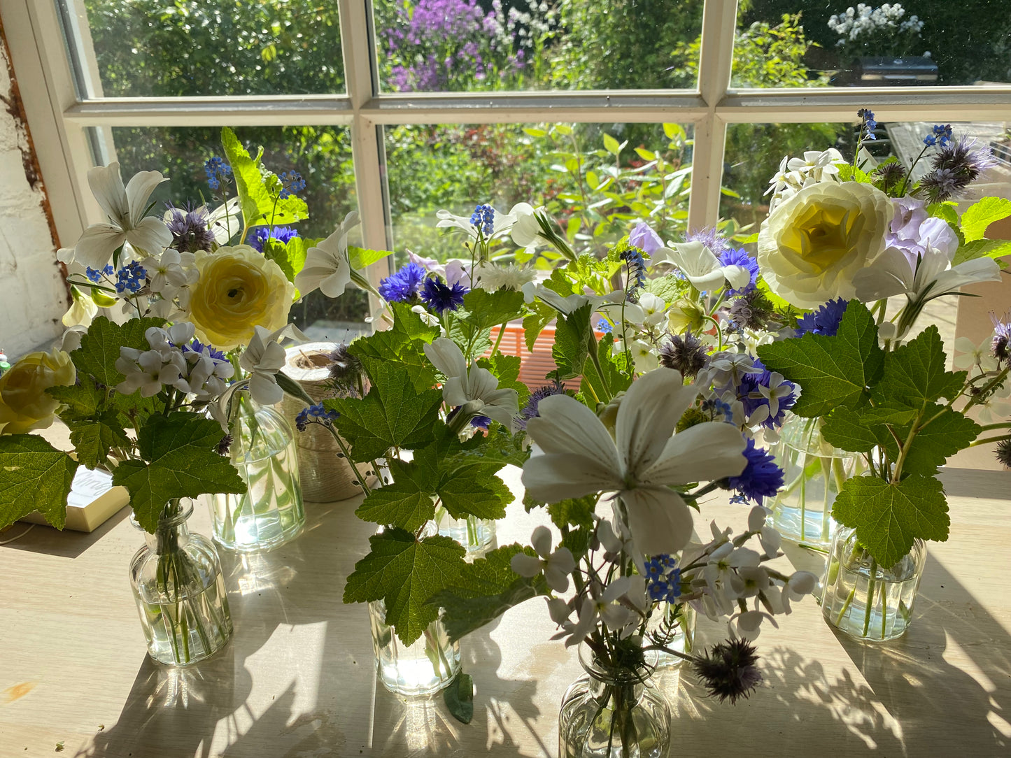 Gevulde kleine tafelvaasjes met verse bloemen