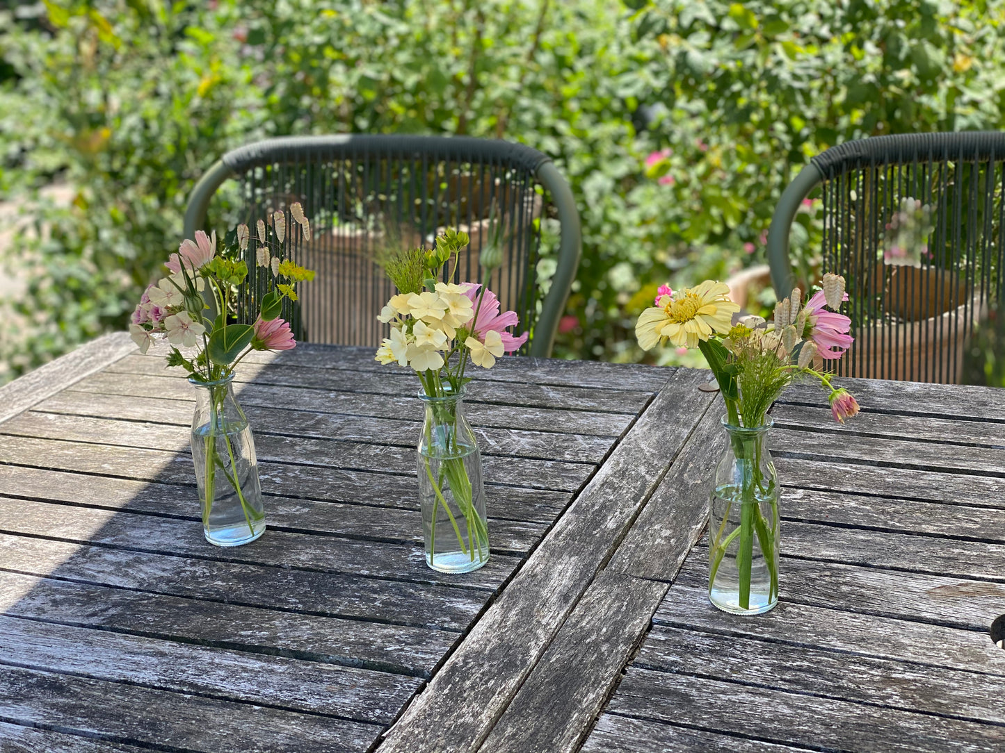 Gevulde kleine tafelvaasjes met verse bloemen